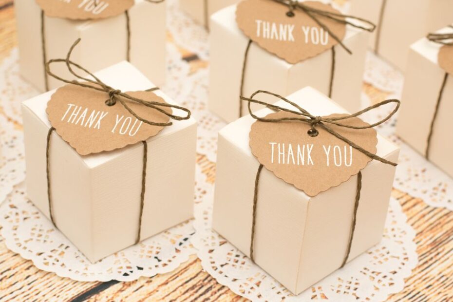 Caixinhas de lembrancinha brancas decoradas com barbante rústico e tag “Thank You”, organizadas sobre toalhinhas rendadas, ideais para eventos e celebrações especiais.